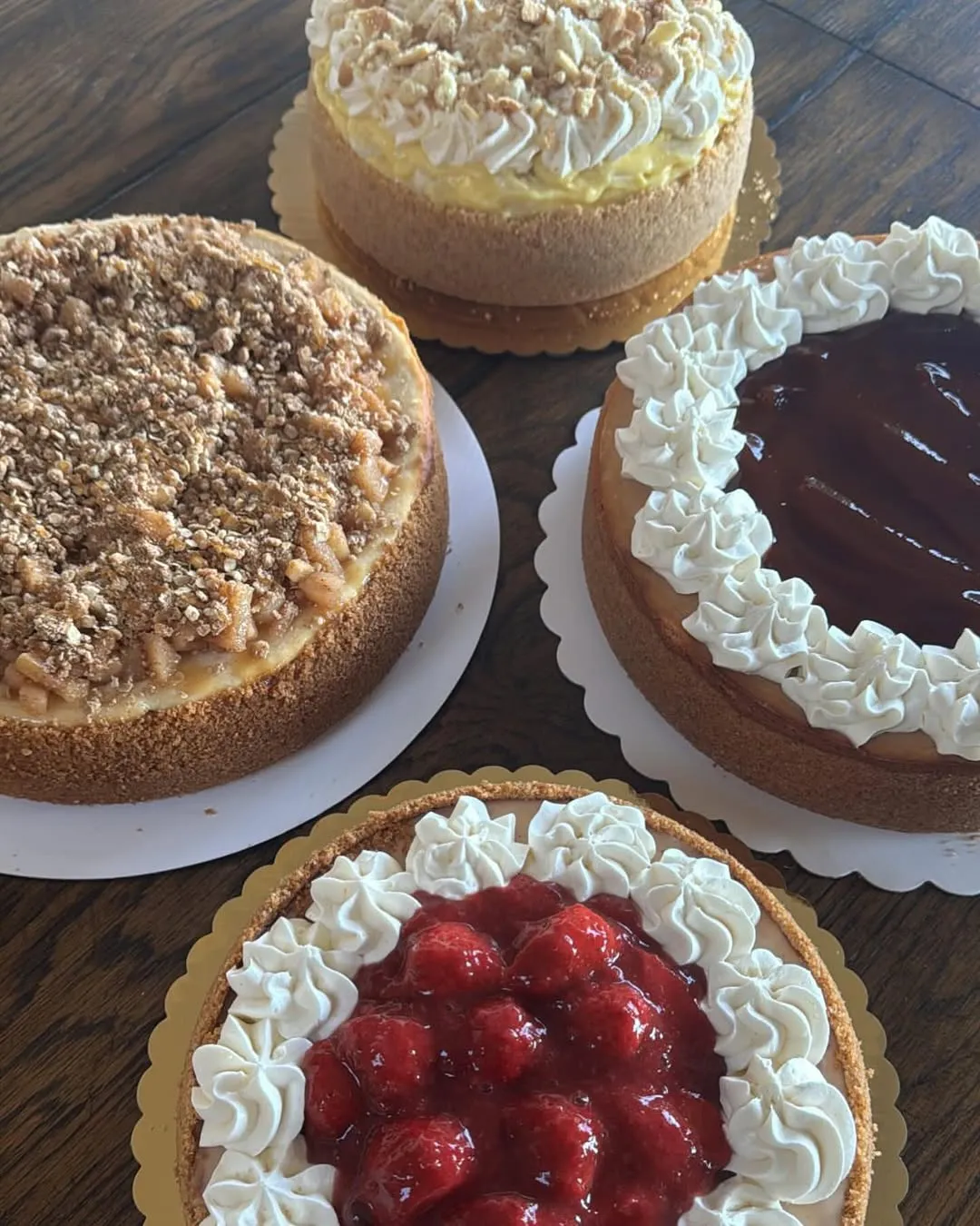 A spread of cheesecakes in different flavours, freshly decorated.