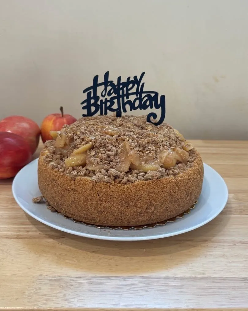 An apple-crumble cheesecake with cinnamon-apple filling and a Happy Birthday topper.