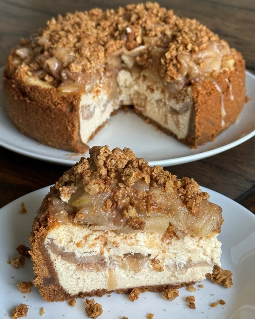 An apple-crumble cheesecake with cinnamon-apple filling and oat streusel, with a slice showing the layers.