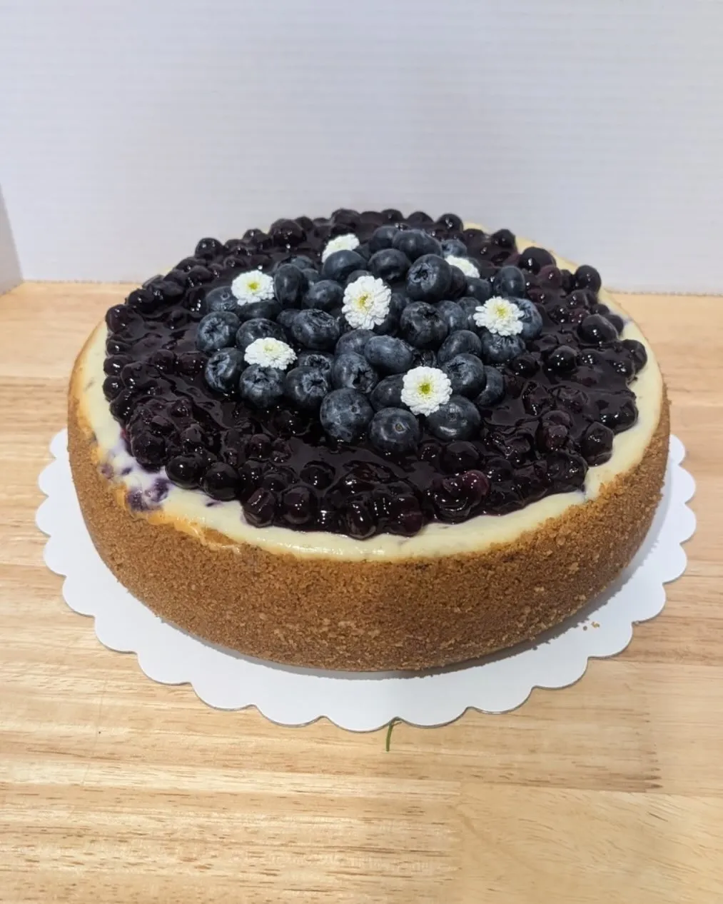 A blueberry cheesecake topped with fresh blueberries and blueberry glaze.