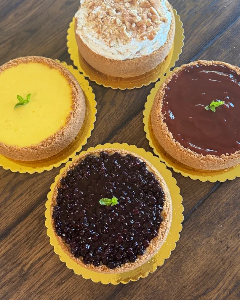 An assortment of cheesecakes including mango, chocolate, blueberry and a cream-topped flavour.