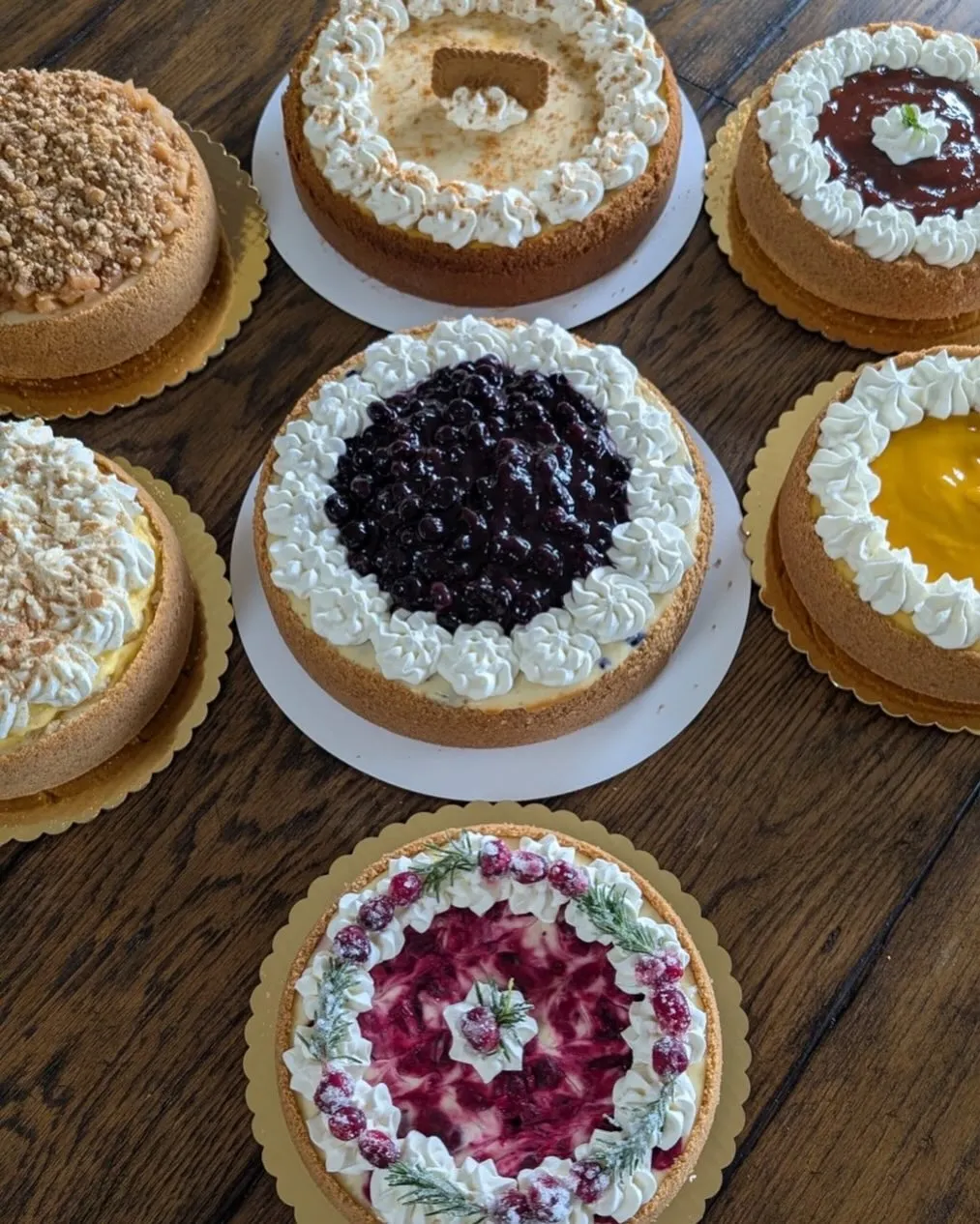 An assortment of handcrafted cheesecakes in different flavours, topped with fruit and cream.