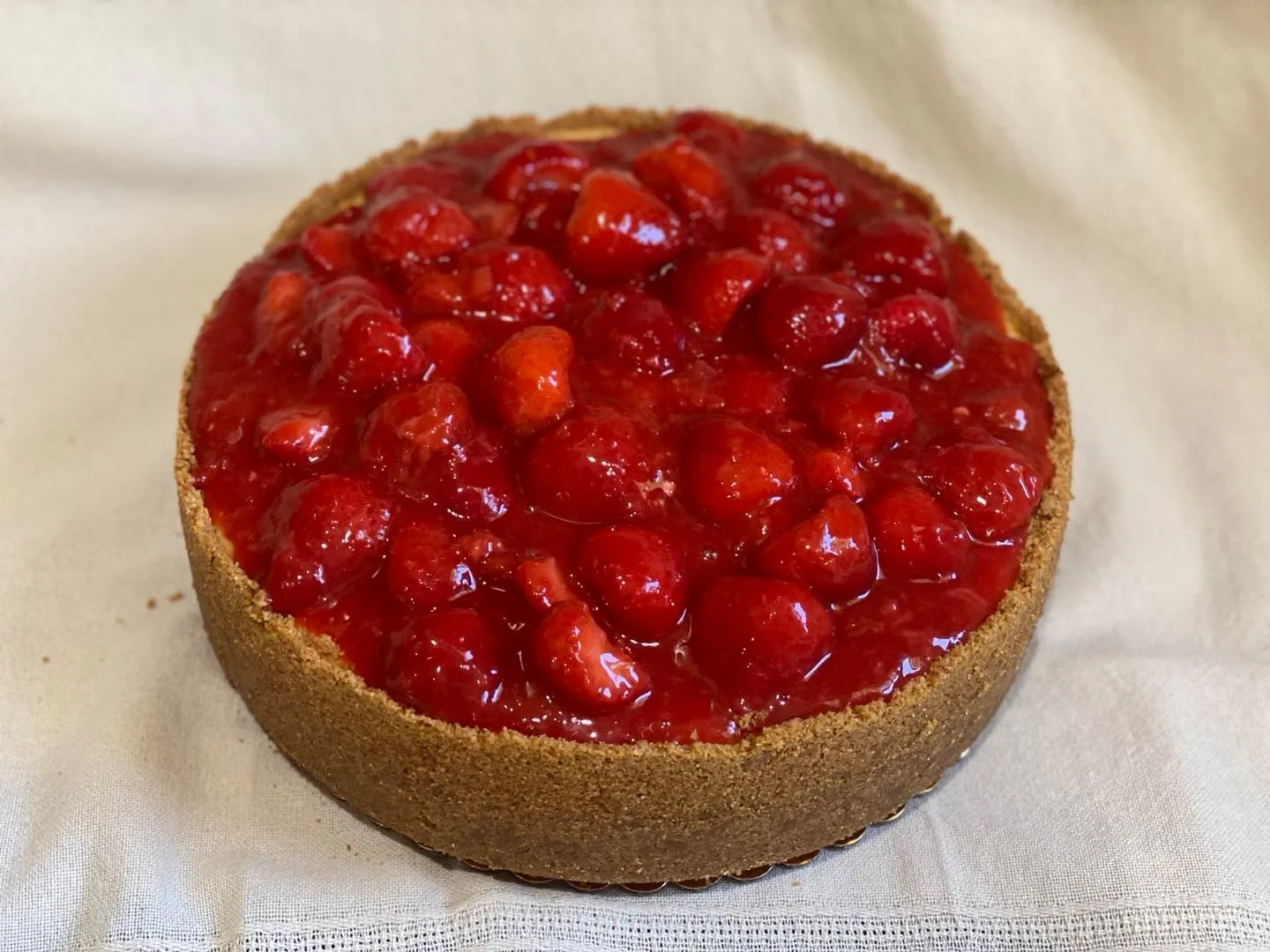 A strawberry cheesecake topped with glazed fresh strawberries.